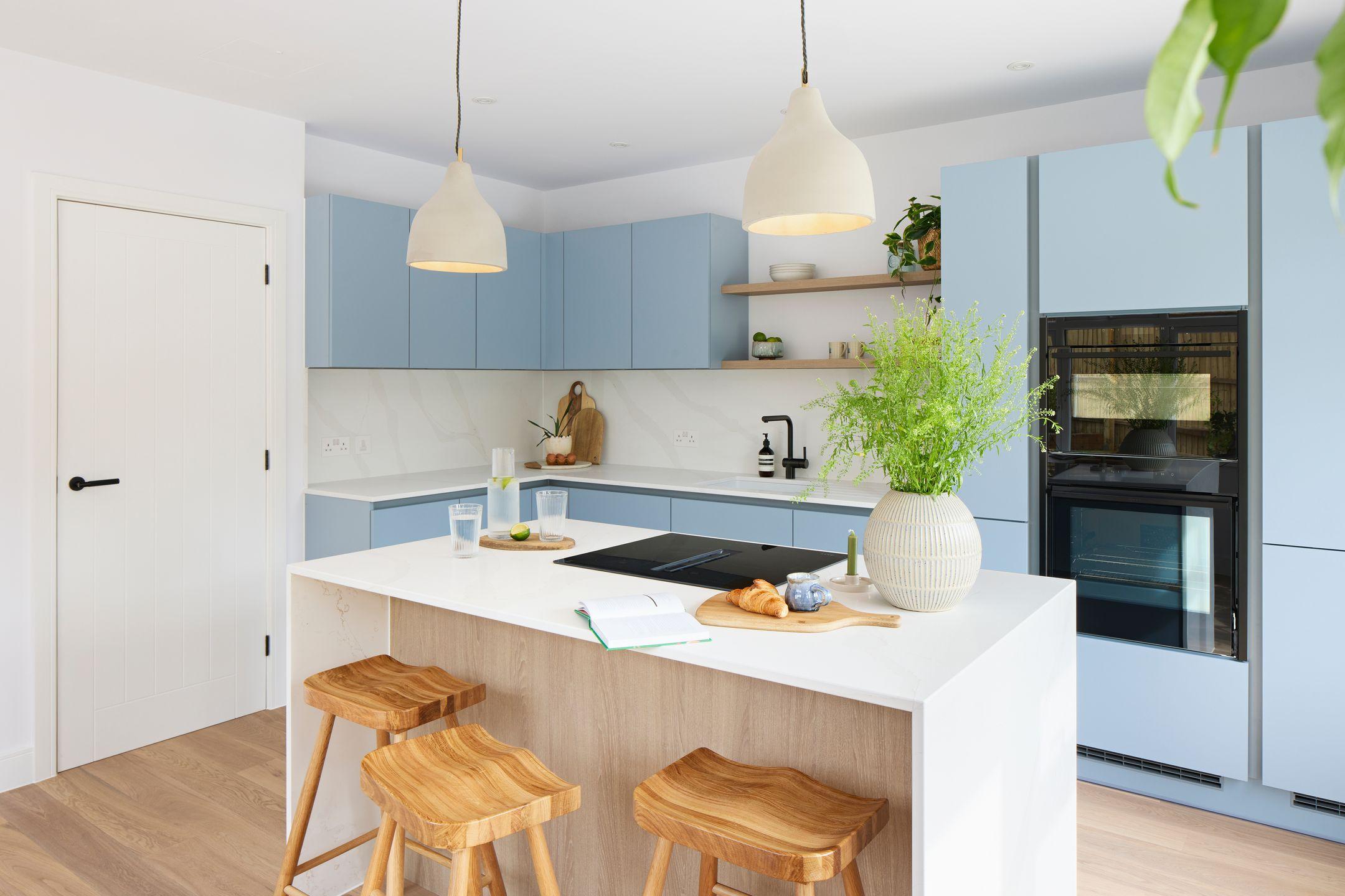 Waterfall kitchen island with wooden accents and stools